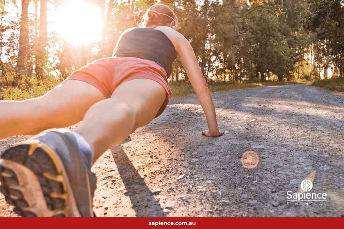 person doing pushups on running trail