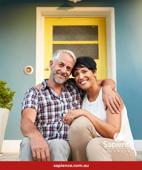 middle aged husband and wife sitting in front step of their home