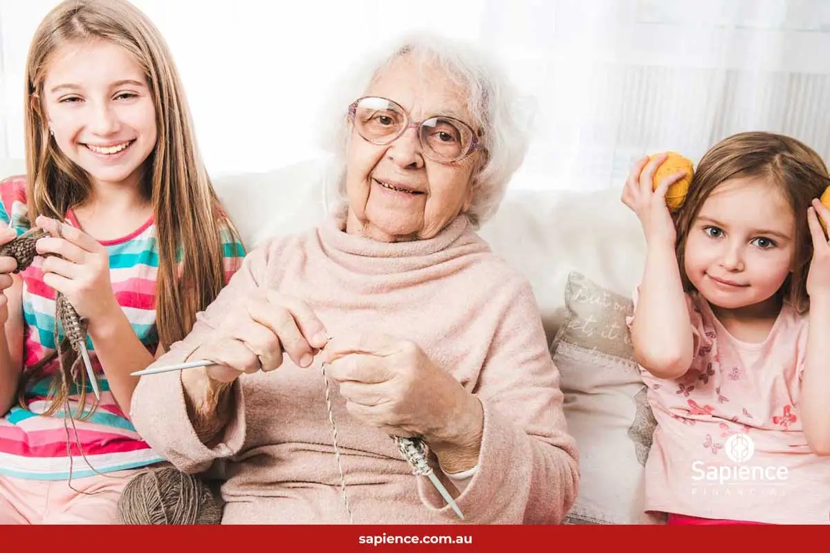 two grandchildren sitting with grandmother on sofa